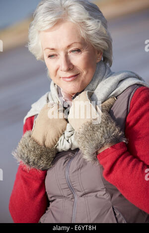 Senior Woman Walking On Winter Beach Stockfoto