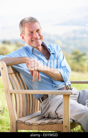 Ältere Mann sitzt im freien Stockfoto