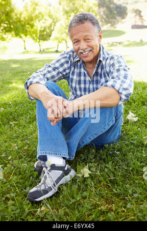 Ältere Mann sitzt im park Stockfoto