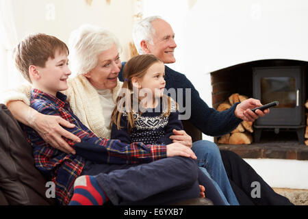 Großeltern auf Sofa vor dem Fernseher mit Enkeln Stockfoto