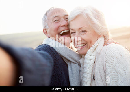 Älteres Paar am Strand nehmen Selfie Stockfoto