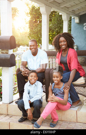 Porträt der Familie sitzt vor Haus Stockfoto