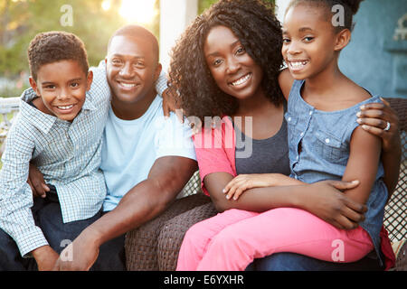 Porträt der Familie sitzt vor Haus Stockfoto