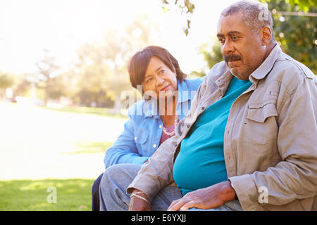 Ältere Frau trösten unglücklich Senior Mann im freien Stockfoto