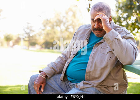 Deprimiert Senior woman, draußen zu sitzen Stockfoto