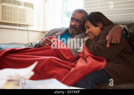 Älteres Paar versucht zu halten Warm unter der Decke zu Hause Stockfoto