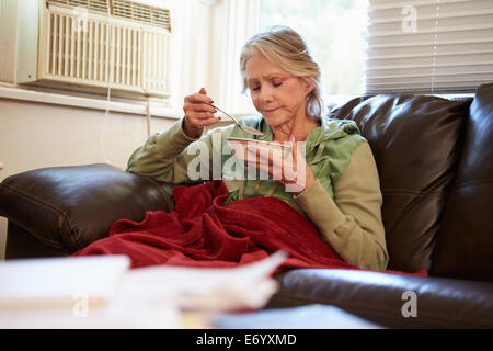 Ältere Frau mit schlechte Ernährung unter Decke Warm zu halten Stockfoto