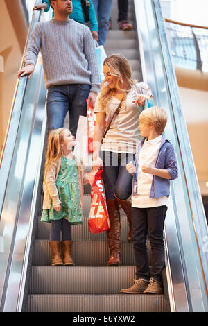 Mutter und Kinder auf Rolltreppe im Einkaufszentrum Stockfoto