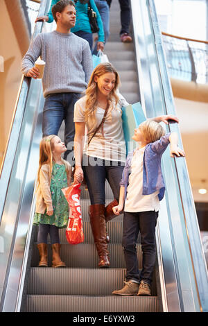 Mutter und Kinder auf Rolltreppe im Einkaufszentrum Stockfoto