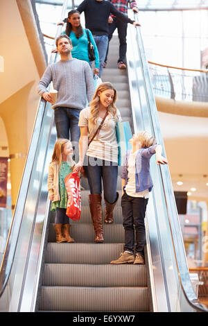 Mutter und Kinder auf Rolltreppe im Einkaufszentrum Stockfoto
