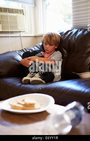 Unglückliche junge zu Hause auf dem Sofa sitzen Stockfoto