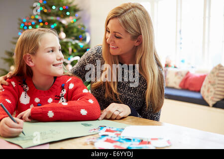 Mutter und Tochter schreiben Brief an den Weihnachtsmann zusammen Stockfoto
