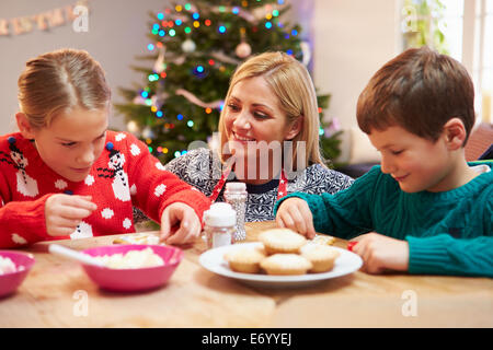 Mutter und Kinder dekorieren Weihnachtsplätzchen zusammen Stockfoto