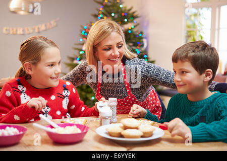 Mutter und Kinder dekorieren Weihnachtsplätzchen zusammen Stockfoto