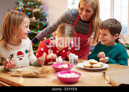 Mutter und Kinder dekorieren Weihnachtsplätzchen zusammen Stockfoto