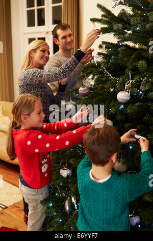 Familie dekorieren Weihnachtsbaum zu Hause zusammen Stockfoto