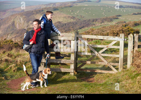 Vater und Sohn mit Hund Küstenweg entlang Stockfoto