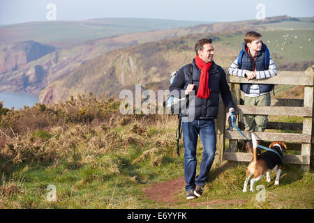 Vater und Sohn mit Hund Küstenweg entlang Stockfoto