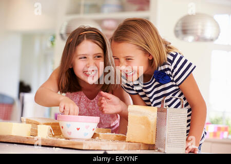 Mädchen, die Zutaten zu essen, während die Käse auf Toast Stockfoto