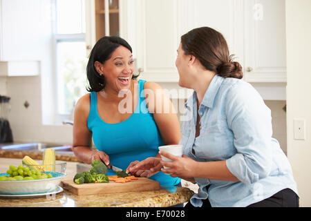 Zwei übergewichtige Frauen auf Diät, die Vorbereitung von Gemüse in der Küche Stockfoto