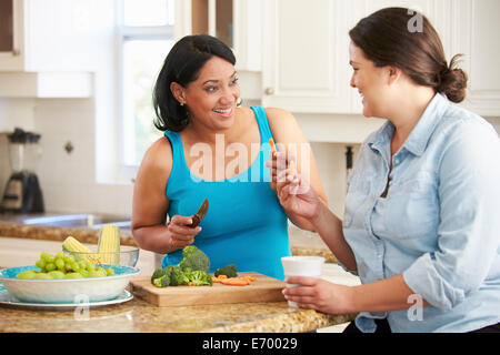 Zwei übergewichtige Frauen auf Diät, die Vorbereitung von Gemüse in der Küche Stockfoto