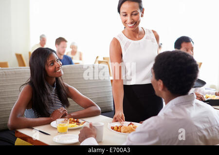 Kellnerin serviert Ihnen paar Frühstück im Hotelrestaurant Stockfoto