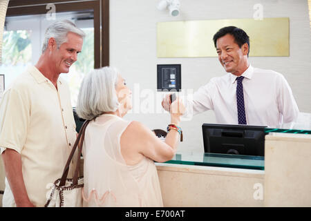 Älteres paar Check-In an der Hotelrezeption Stockfoto