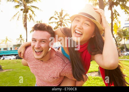 Junge Paare, die Spaß im Park zusammen Stockfoto