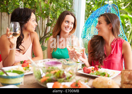 Drei Freundinnen, die Mahlzeit im Freien zu Hause genießen Stockfoto