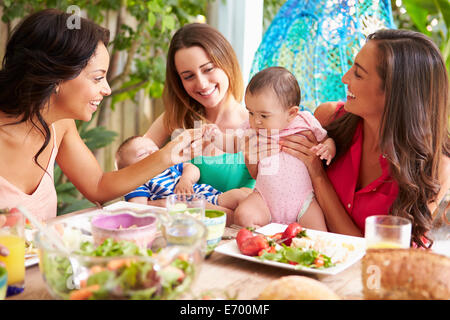 Gruppe von Müttern mit Babys Mahlzeit im Freien zu Hause genießen Stockfoto