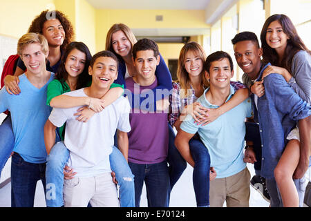 Gruppe von Schülerinnen und Schüler geben Piggybacks im Korridor Stockfoto