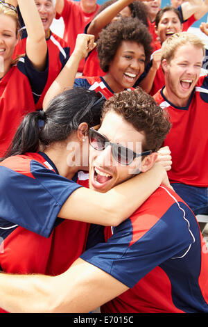 Sport-Zuschauer In Teamfarben feiern Stockfoto