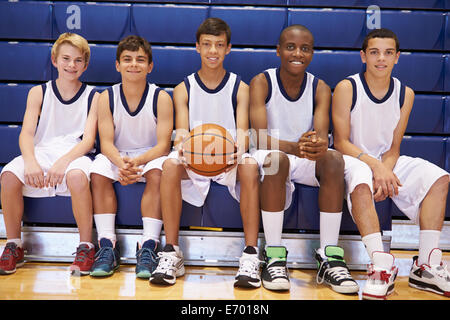 Mitglieder des männlichen High-School Basketballteam auf Bank Stockfoto