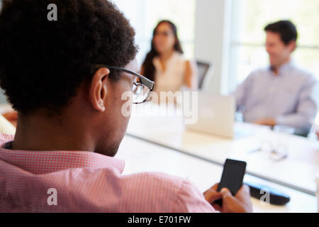 Designer mit Handy während der Sitzung Stockfoto