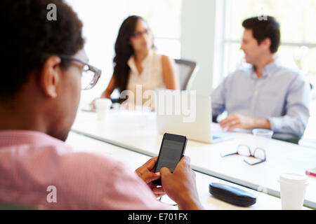 Designer mit Handy während der Sitzung Stockfoto