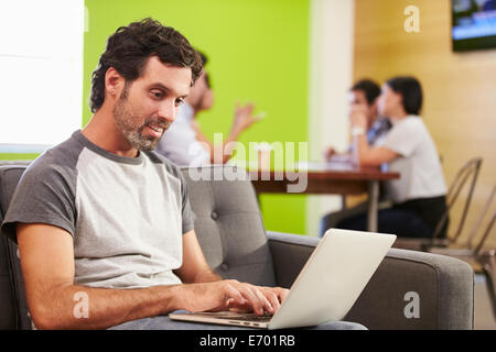 Mann auf Sofa sitzen und arbeiten im Designstudio Stockfoto