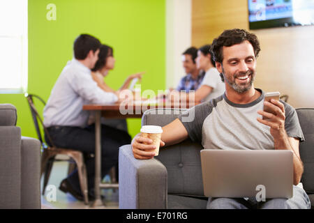 Mann auf Sofa sitzen und arbeiten im Designstudio Stockfoto