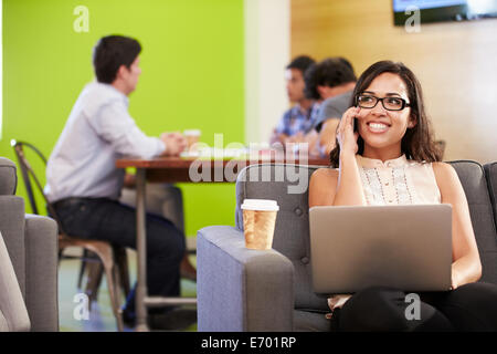 Frau auf dem Sofa sitzen und arbeiten In Design-Studio Stockfoto