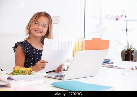 Mädchen, die vorgibt, Geschäftsfrau, die Arbeiten am Schreibtisch Stockfoto