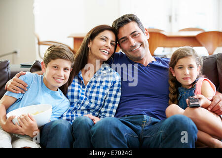 Familie sitzt auf dem Sofa vor dem Fernseher zusammen Stockfoto