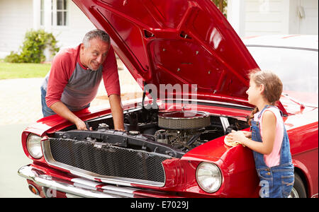 Großvater und Enkelin arbeiten an Oldtimer Stockfoto