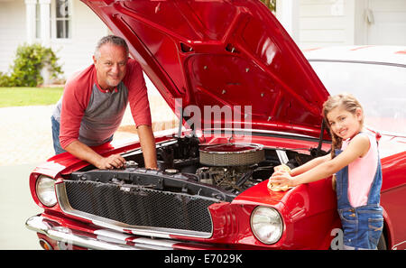 Großvater und Enkelin arbeiten an Oldtimer Stockfoto