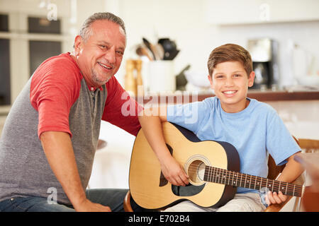 Großvater Lehre Enkel, Gitarre zu spielen Stockfoto