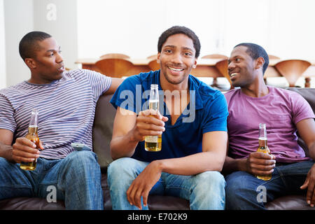 Gruppe von Männern sitzt auf dem Sofa vor dem Fernseher zusammen Stockfoto