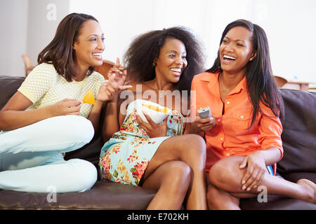 Gruppe von Frauen, die sitzen auf dem Sofa vor dem Fernseher zusammen Stockfoto