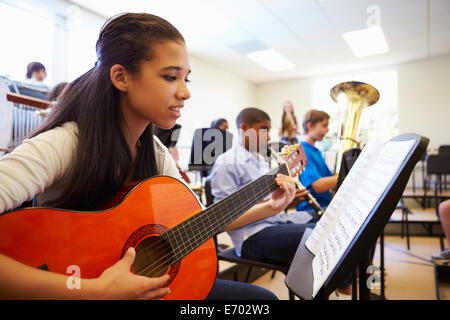 Weibliche Schüler spielt Gitarre In High School Orchestra Stockfoto