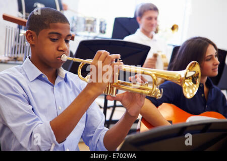 Männliche Schüler Trompete In High School Orchestra Stockfoto