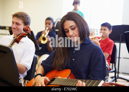 Weibliche Schüler spielt Gitarre In High School Orchestra Stockfoto