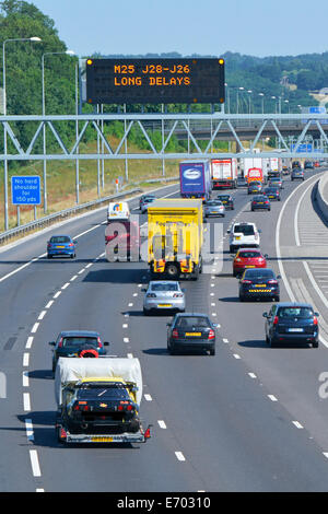 Autobahnverkehr & digitale elektronische Technologie Straßenschild mit Vorwarnung lange Verzögerungen im Uhrzeigersinn M25 Route nächste Kreuzung 28 Brentwood UK Stockfoto
