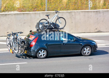 Auto fahren auf Autobahn mit Dachgepäckträger & -Top-Box ausgestattet mit Fahrrad auch mit hinten montierten Zyklus Rack (verdeckt Nummernschilder) Stockfoto